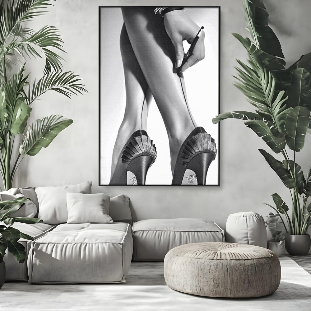 Tablou canvas cu tablou alb-negru picioare dama si pantofi cu toc, in rama de aluminiu negru, pe perete intr-un living